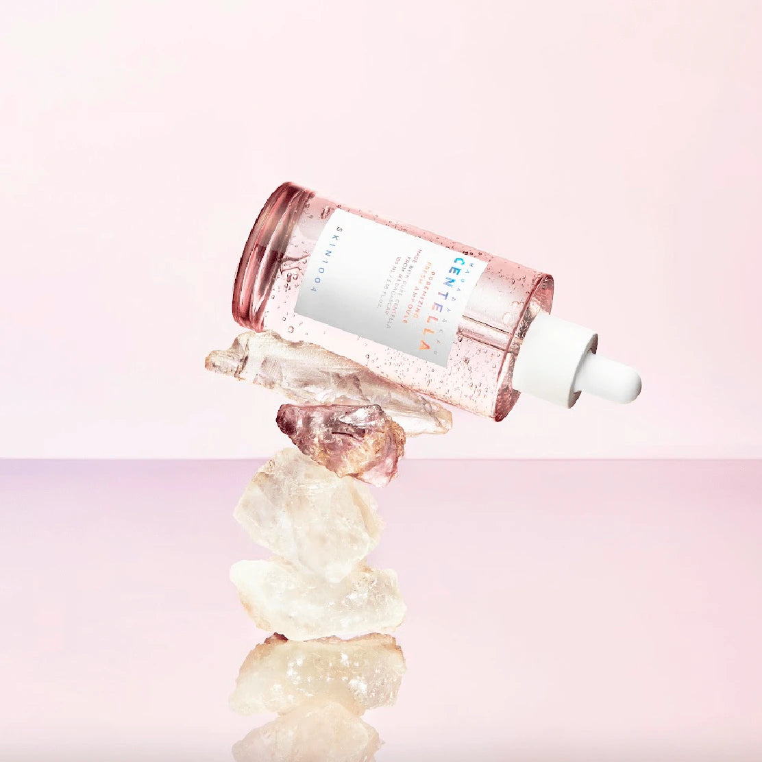 Skincare bottle with dropper on a pink background