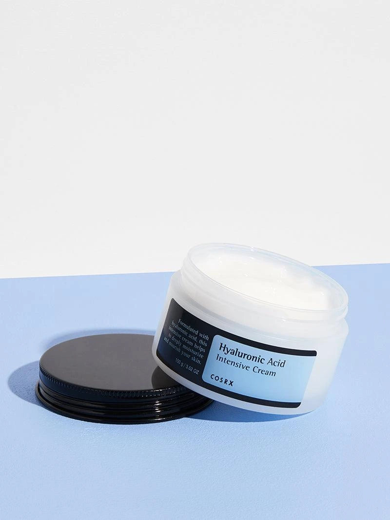 CosRX Hyaluronic Acid Intensive Cream jar on a light blue background