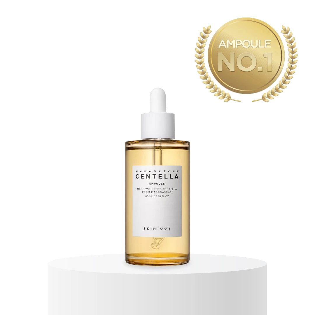Skincare ampoule bottle with a gold label on a white background