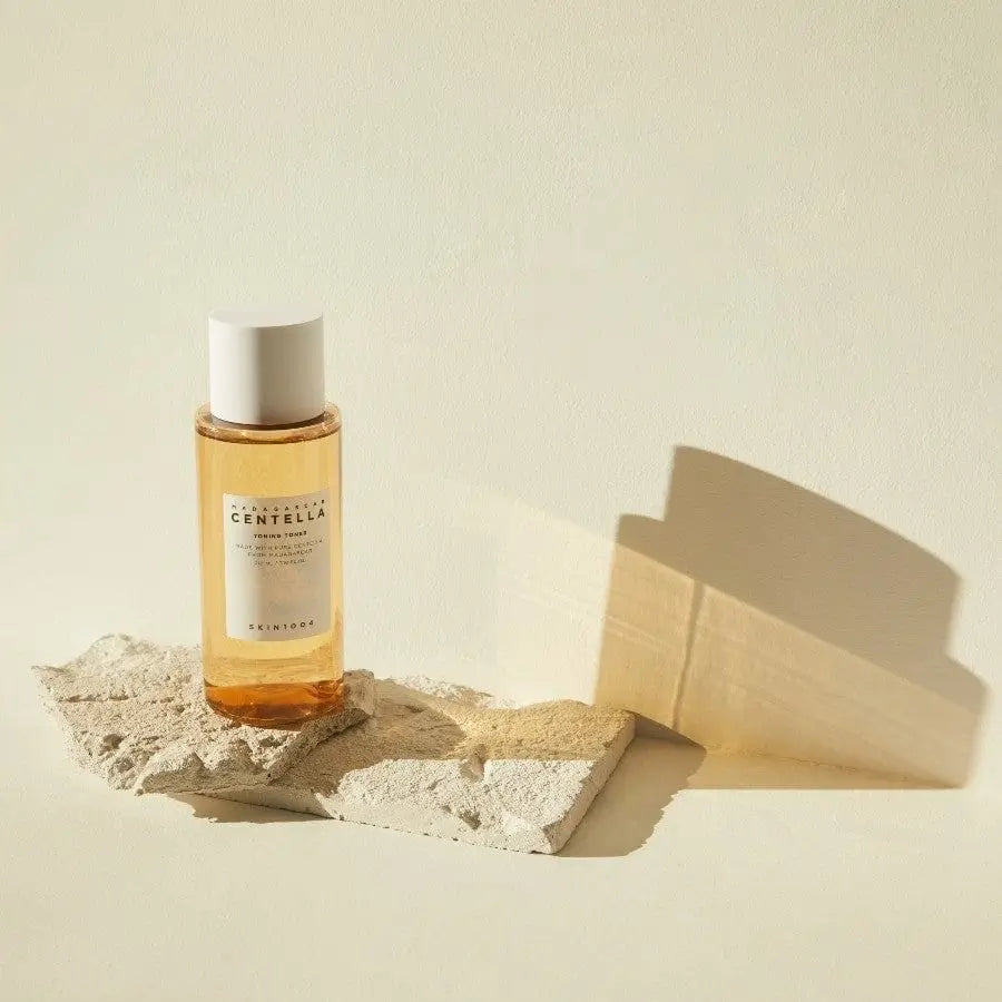 Skincare bottle labeled 'Centella' on a textured surface with a light background