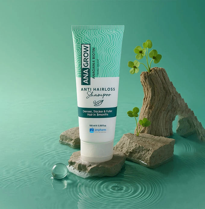 Tube of AnaGrow Anti Hairloss Shampoo on a natural stone surface with a green background