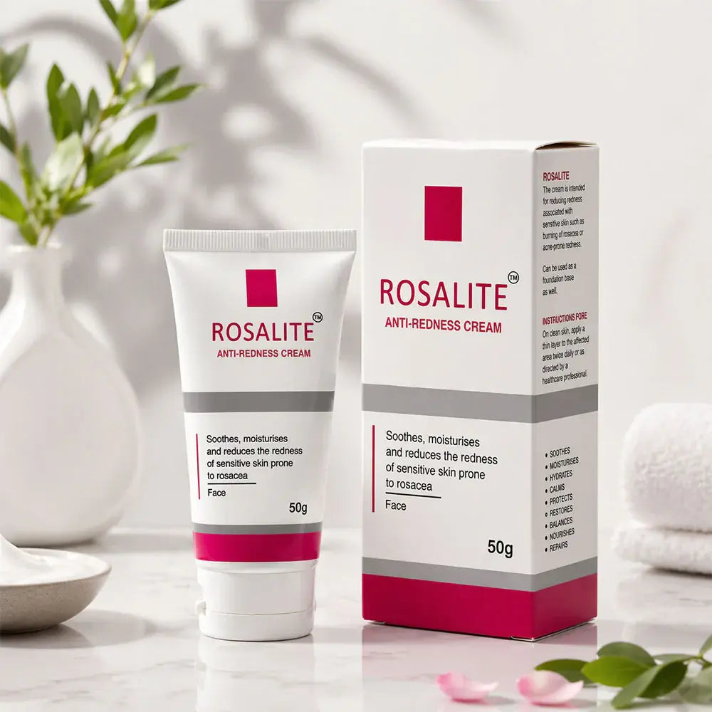 A 50g tube and box of ROSALITE Anti-Redness Cream for sensitive skin, styled on a marble surface with soft shadows, a white vase with green leaves, and a rolled towel in the background.