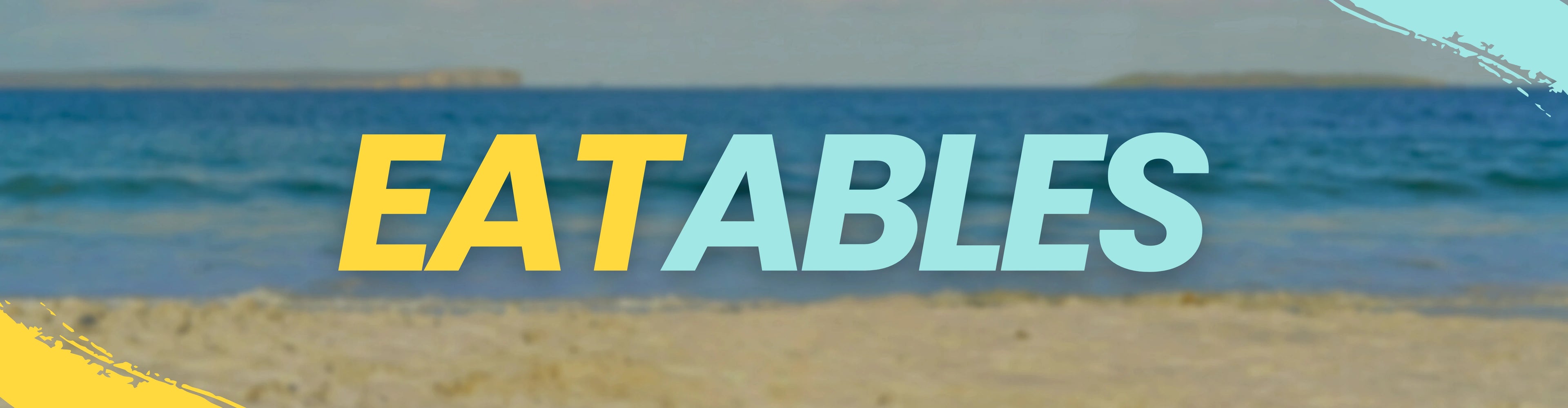 Text 'EATABLES' over a blurred beach scene with blue water and sand.
